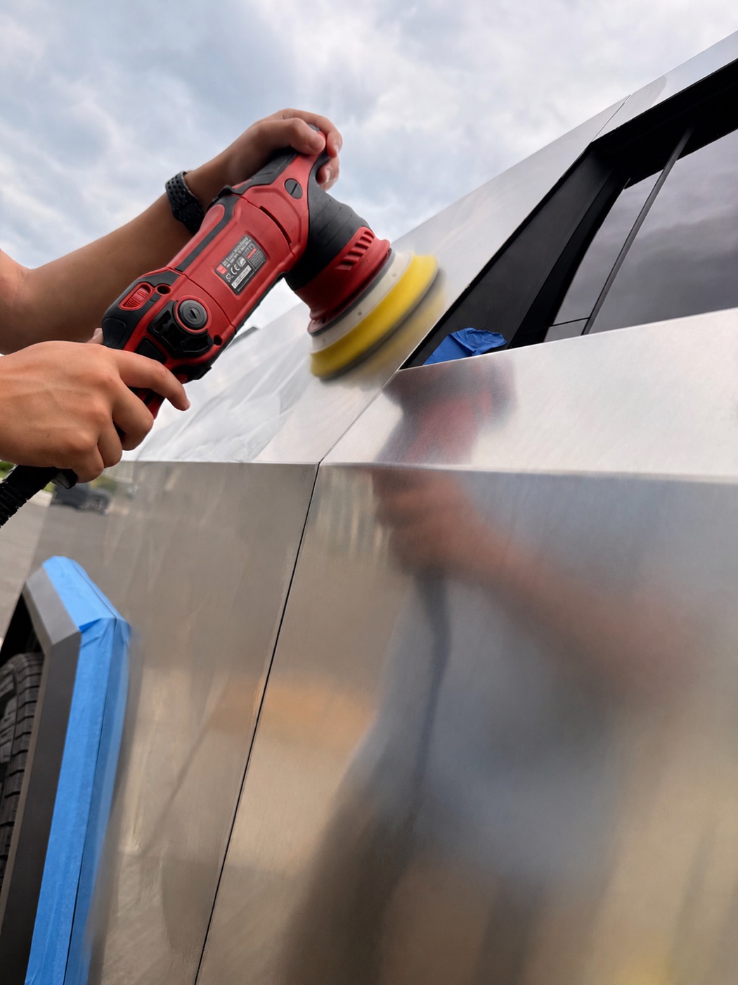 Paint correction polisher in action on a Cybertruck panel